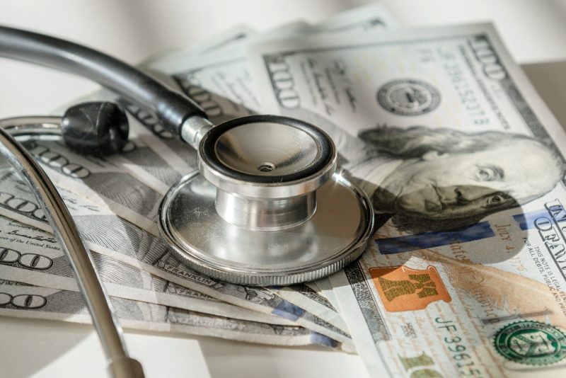 US currency with stethoscope struggling economy